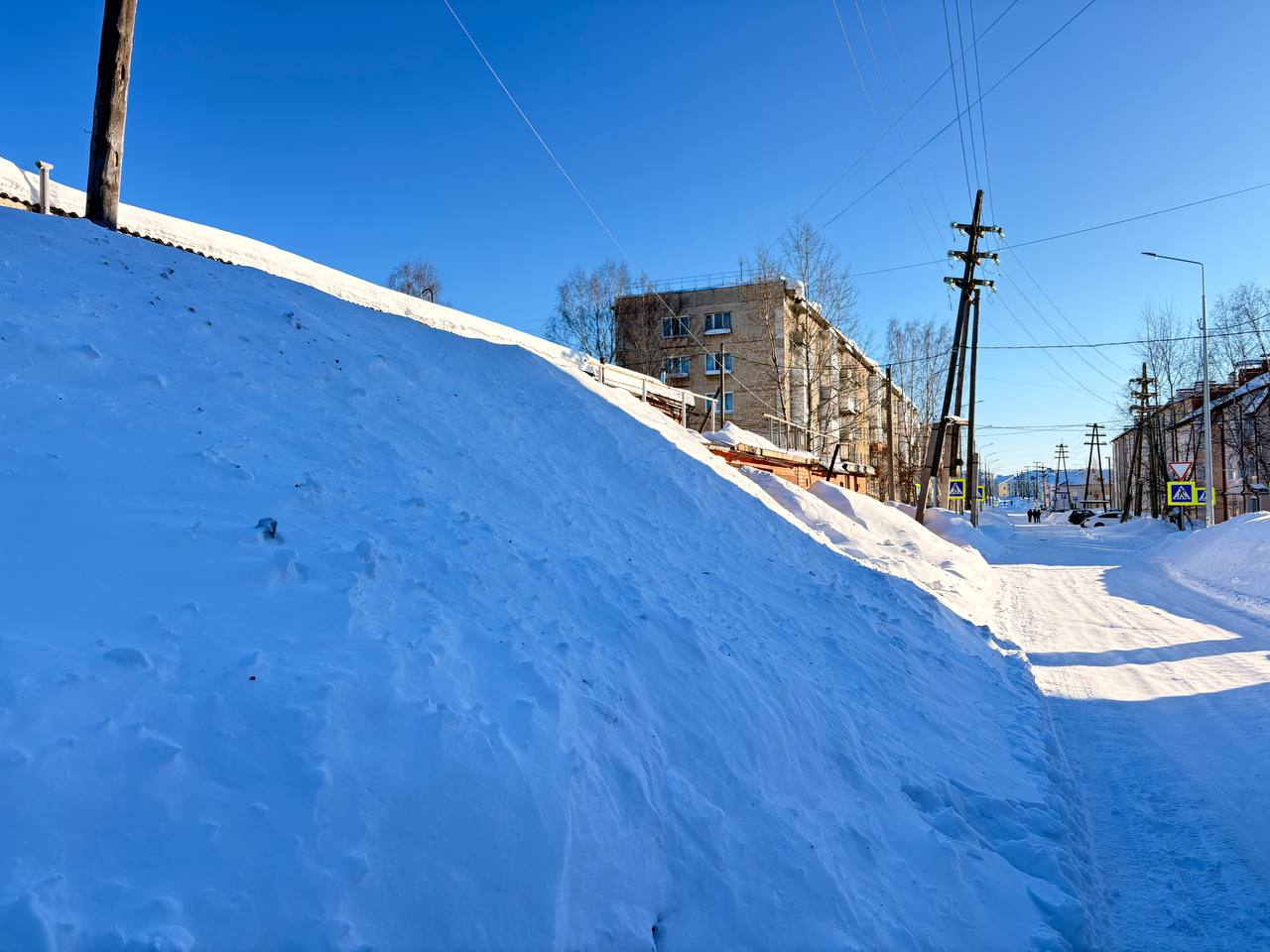 Горожане указывают на снежные валы у проезжей части по 8 Марта, которые дети используют как горку
