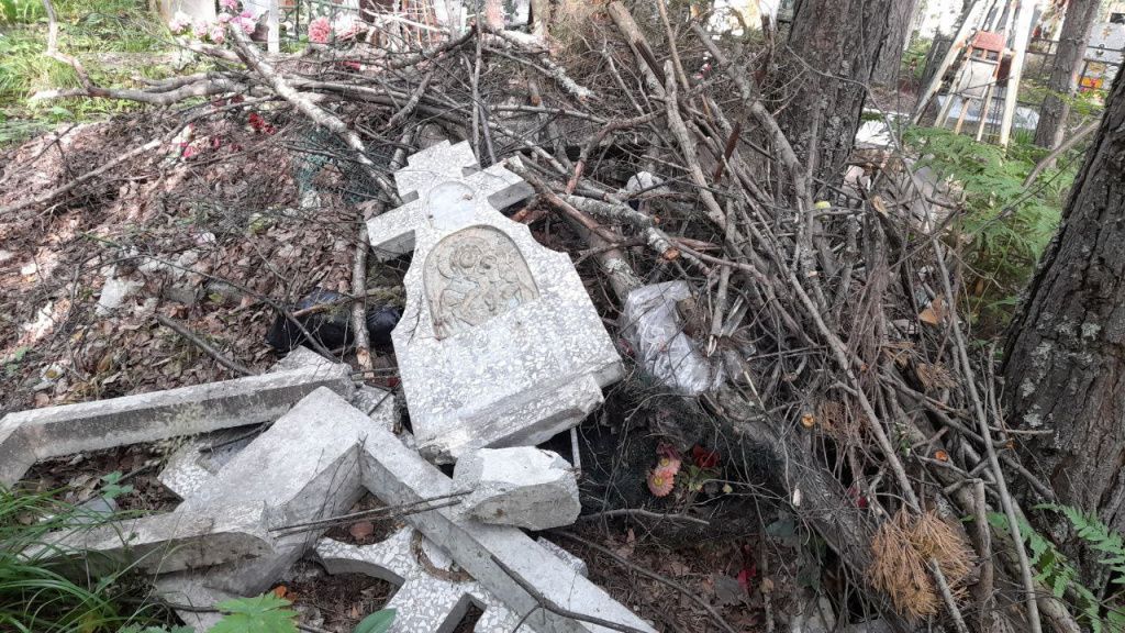 На стихийную свалку выкинули памятник в виде креста с литым рельефным изображением иконы Божией Матери с младенцем Христом на руках. Табличку с фото и ФИО усопшего сняли. Фото: Андрей Гребенкин, «Глобус»