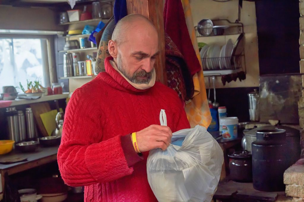 Саныч принимает пакет, доставленный снизу. Все подаренное и пожертвованное монастырю считается подношением. Фото: Вадим Аминов, "ВК - Медиа"